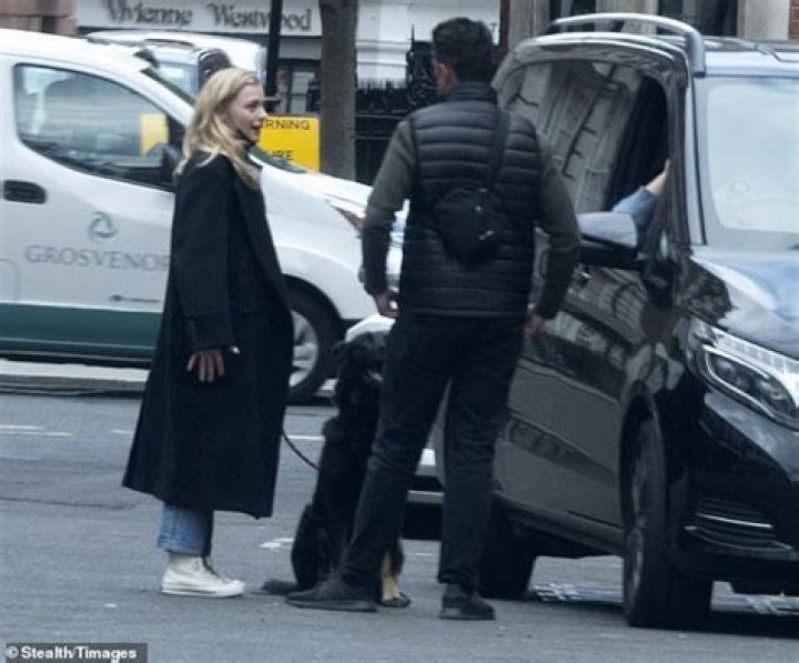 Practical: Her companion kept a low profile in a padded gilet and green jumper which he teamed with jeans
